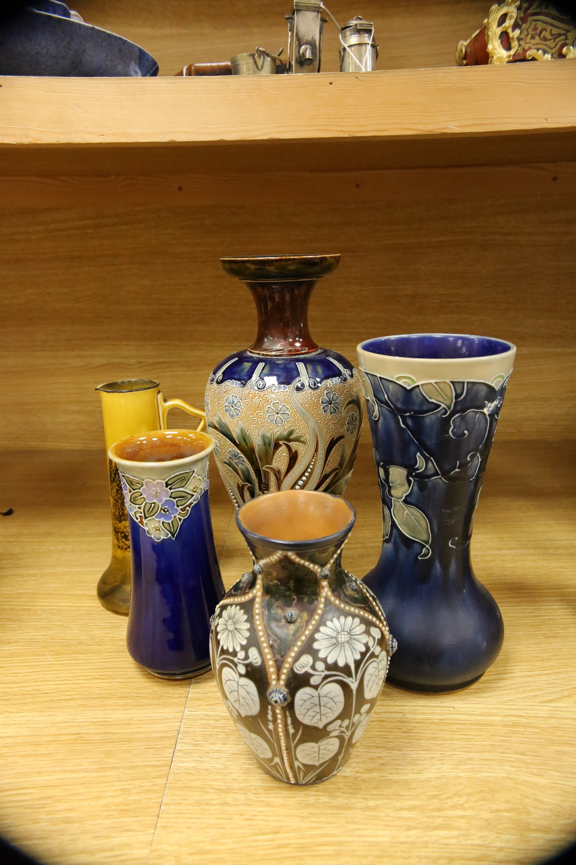 Four Royal Doulton vases and a yellow glazed jug items, tallest vase 34cm high. Condition - some crazing and faults, large vase has damage to lower neck